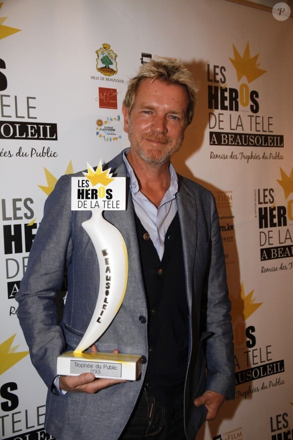 Xavier Deluc tient le trophée du public au 2e festival "Les Héros de la Télé" à Beausoleil, le 5 octobre 2013.