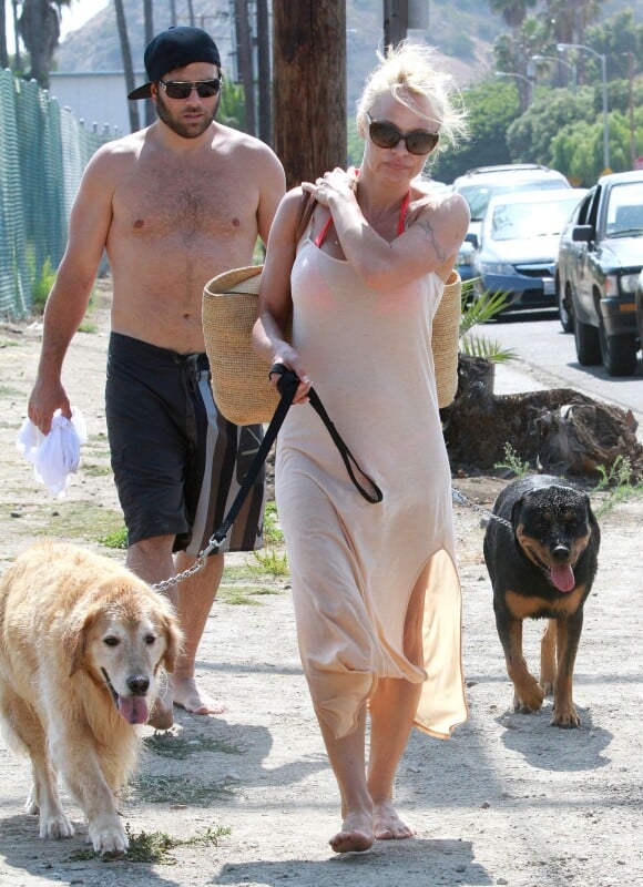 Pamela Anderson et son ex mari Rick Salomon quittent la plage de Malibu le 5 juillet 2013 avec leurs deux chiens dont le rottweiller de Rick et le labrador de Pamela.