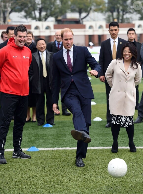 Le prince William montrant ses talents de footballeur au lycée de Nanyang, le 3 mars 2015 lors de sa visite officielle en Chine.