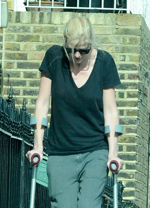 Lara Stone marche avec des béquilles avec une attelle au pied dans la rue dans le nord de Londres, le 12 mars 2015, tout juste séparée de son mari David Walliams.