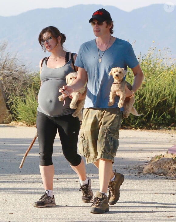 Exclusif - Milla Jovovich très enceinte fait de la randonnée avec son mari Paul W.S Anderson et leurs chiens à Los Angeles, le 24 mars 2015.  