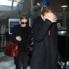 Les jumelles Mary-Kate et Ashley Olsen arrivent a l'aeroport de Los Angeles, le 14 novembre 2013. Ashley est celle qui porte un sac rouge. 