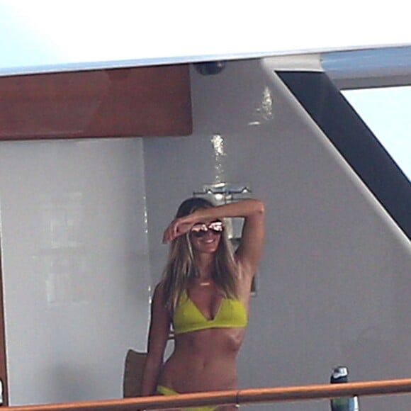 Elle Macpherson, très sexy en maillot de bain jaune, se détend sur un yacht au large de Saint-Tropez, le 12 juillet 2015.