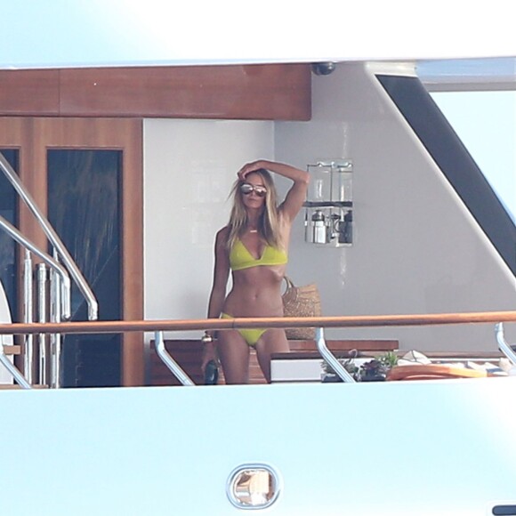 Elle Macpherson, très sexy en maillot de bain jaune, se détend sur un yacht au large de Saint-Tropez, le 12 juillet 2015.