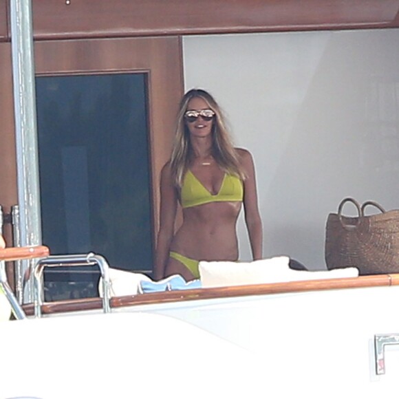 Elle Macpherson, très sexy en maillot de bain jaune, se détend sur un yacht au large de Saint-Tropez, le 12 juillet 2015.