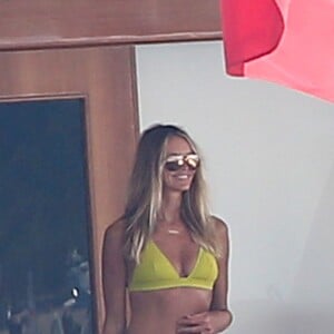 Elle Macpherson, très sexy en maillot de bain jaune, se détend sur un yacht au large de Saint-Tropez, le 12 juillet 2015.