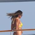 Elle Macpherson, très sexy en maillot de bain jaune, se détend sur un yacht au large de Saint-Tropez, le 12 juillet 2015.