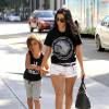 Kourtney Kardashian va faire du shopping avec son fils Mason à Beverly Hills, habillée d'un t-shirt noir, d'un mini-short blanc One Teaspoon et de bottines Saint Laurent. Des lunettes de soleil, une ceinture Saint Laurent et un sac Hermès (modèle Birkin) accessoirisent sa tenue. Le 3 août 2015.
