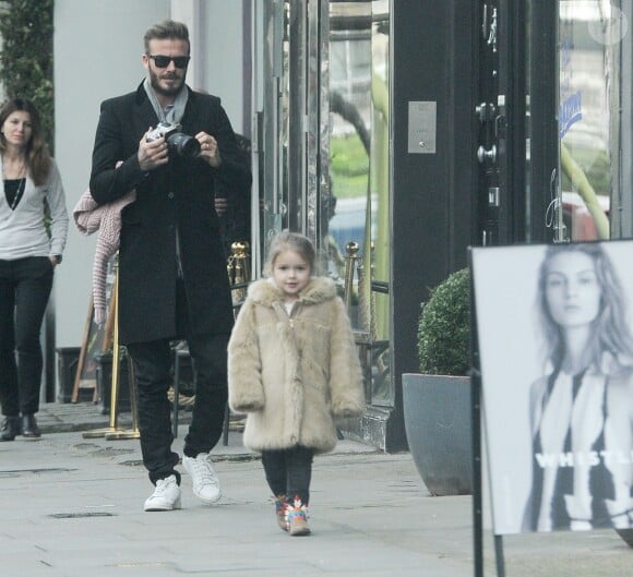Papa Beckham prend en photo sa princesse vêtue d'un manteau de fourrure Chloe, d'un jean noir et de bottines indiennes Stella McCartney, le 4 février 2015 à Londres 