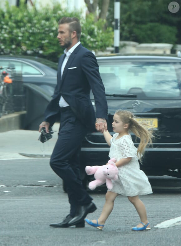 En petite robe blanche Chloe et chaussures bleues, Harper et David Beckham se rendent à une soirée parents à l'école de la petite fille, le 7 juillet 2015 à Londres