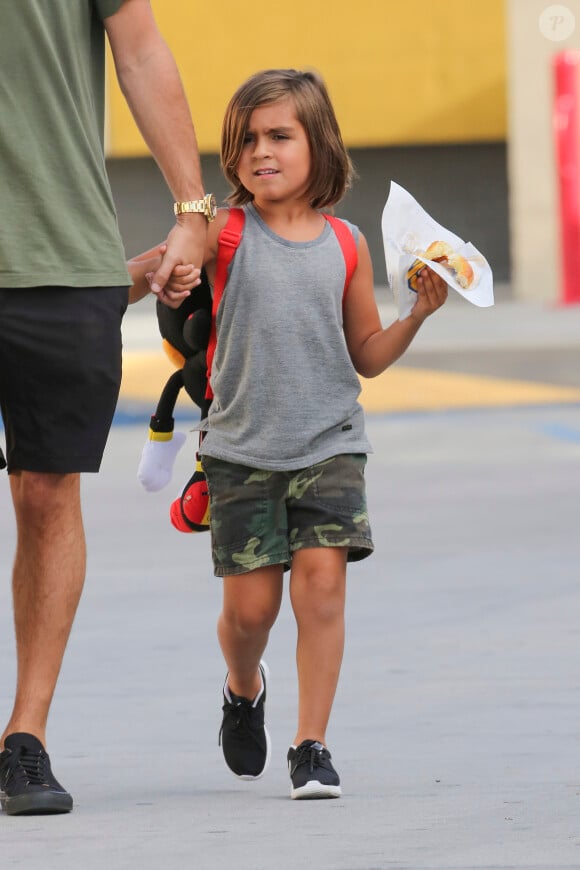 De sortie avec papa, le petit Mase a déjà adopté le motif camouflage sur le short qu'il porte, accompagné d'un débardeur gris et de sneakers noires Nike, le 30 juillet 2015 à Los Angeles