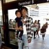All black look, dans les bras de papa, le petit Sebastian Taylor s'apprête à quitter Los Angeles, le 21 août 2014 à l'aéroport LAX