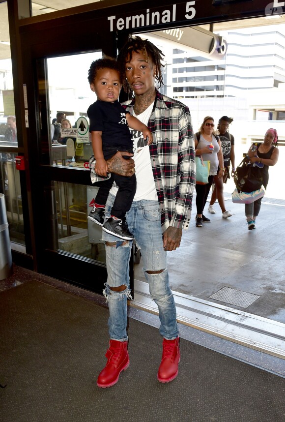 All black look, dans les bras de papa, le petit Sebastian Taylor s'apprête à quitter Los Angeles, le 21 août 2014 à l'aéroport LAX