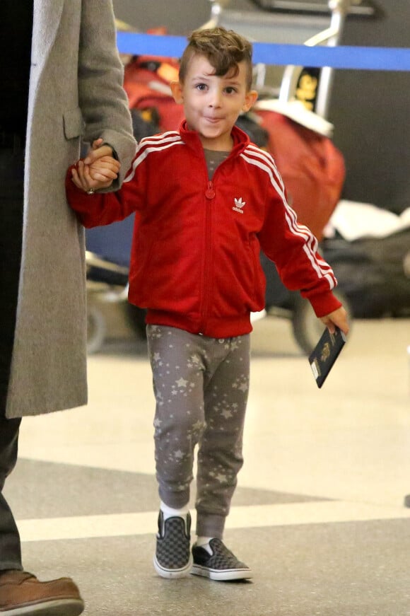 En tenue de sport : ensemble jogging gris à étoiles, veste rouge Adidas, et slip-ons à carreaux Vans, le 3 juin 2015 à l'aéroport de Los Angeles