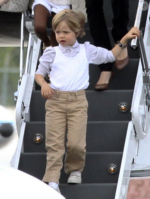 Notre petit garçon manqué préféré adopte un look plus chic : chemise, pantalon et sneakers blanches, pour son arrivée à Cancun au Mexique le 29 juin 2010