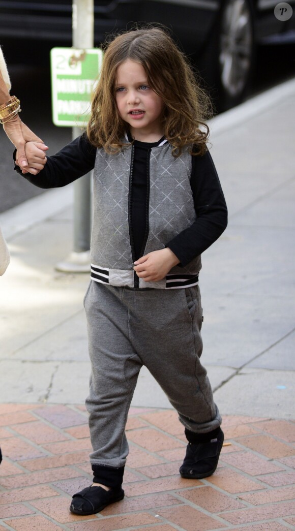 Habillé d'une tenue grise et de petits mocassins noirs, il tient la main de sa mère qui est venu le chercher à la sortie de l'école, dans le quartier de Beverly Hills à Los Angeles le 26 mai 2015