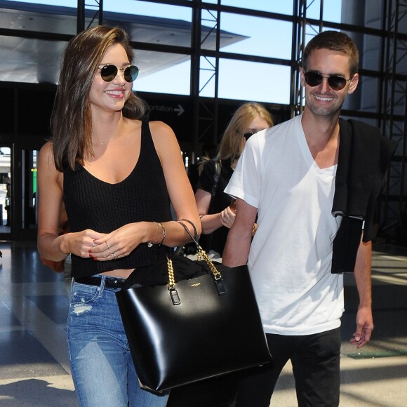 Miranda Kerr prend l'avion à l'aéroport de Los Angeles avec son nouveau petit-ami Evan Spiegel, le 12 août 2015. Evan Spiegel est un entrepreneur américain et cofondateur et CEO de l'application mobile Snapchat. Miranda et Evan semblent très amoureux!  Miranda Kerr is all smiles while departing on a flight at LAX airport in Los Angeles, California with her new boyfriend Evan Spiegel on August 12, 2015. The 32-year-old model and her 25-year-old billionaire boyfriend couldn't keep their hands off of each other while they waited for their flight!12/08/2015 - Los Angeles