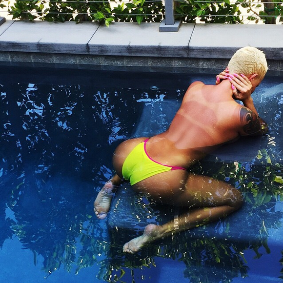 Amber Rose, topless dans sa piscine, révèle ses marques de bronzage. Photo publiée le 29 mai 2015.