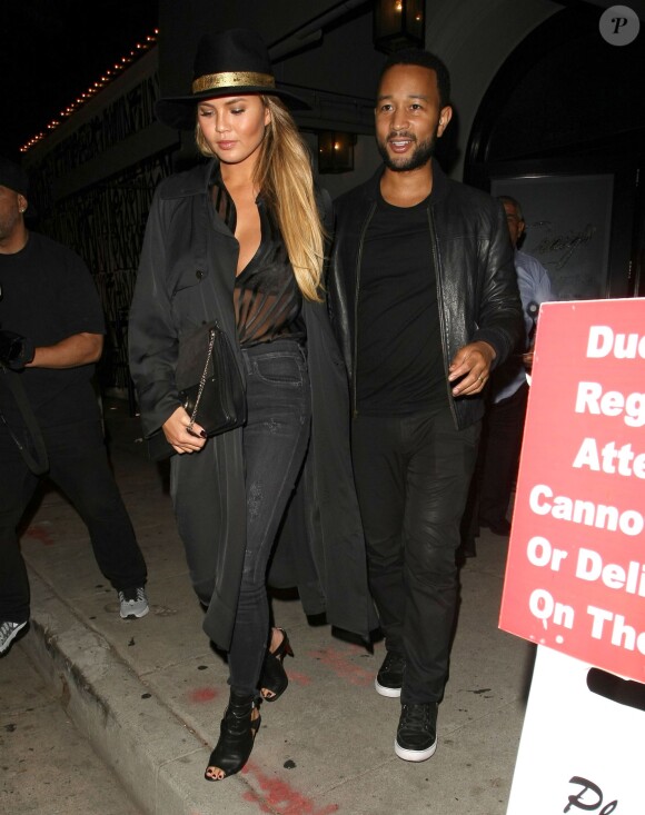 John Legend et sa femme Chrissy Teigen, tout de noir vêtue et tenant un sac Chloé (modèle Faye), quittent le restaurant Craig à West Hollywood. Le 31 août 2015.