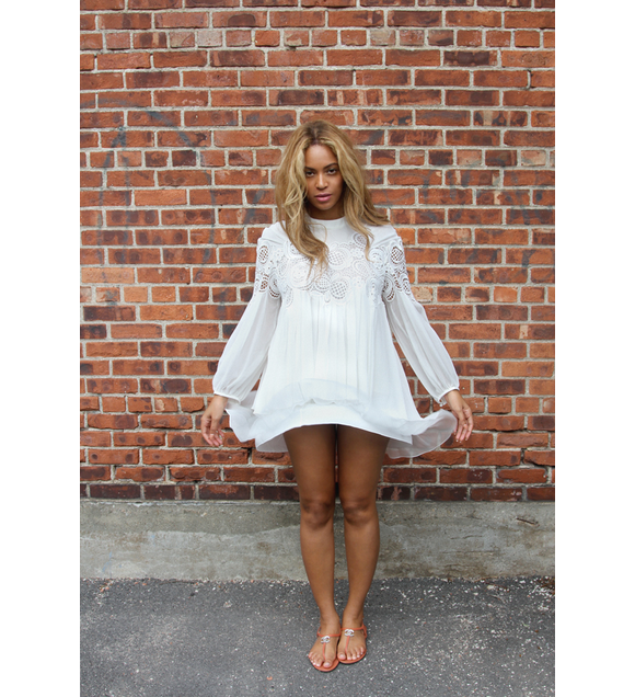 Beyoncé, ravissante dans son top blanc en dentelle et coton (collection automne-hiver 2015), sa jupe assortie Chloé et des sandales Chanel, pose devant un mur de briques. Photo publiée le 1er septembre 2015.