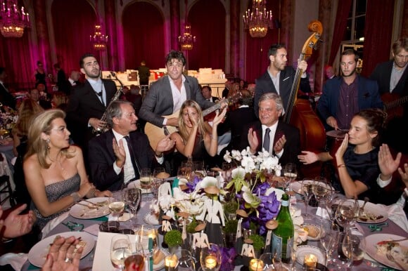 Le groupe The Gypsy Queens à la table de Mélanie Laurent, Sidney Toledano et Ana Girardot lors du 18e Grand Bal de Deauville, au profit de l'association Care France. Deauville, le 29 août 2015.