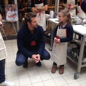 Bradley Cooper avec une apprentie cuisinière chez L'Atelier du Chef à Paris le 25 octobre 2015.