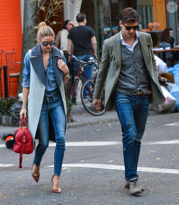 Olivia Palermo et son mari Johannes Huebl se promènent en amoureux dans les rues de New York, le 3 novembre 2015. Olivia porte un manteau sans manche Gestuz, une chemise en denim et un jean, un sac Louis Vuitton accessoirisé d'un Fendi Bag Bug, et des souliers marrons. Le 3 novembre 2015.