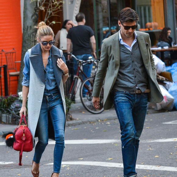 Olivia Palermo et son mari Johannes Huebl se promènent en amoureux dans les rues de New York, le 3 novembre 2015. Olivia porte un manteau sans manche Gestuz, une chemise en denim et un jean, un sac Louis Vuitton accessoirisé d'un Fendi Bag Bug, et des souliers marrons. Le 3 novembre 2015.