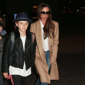 David, Victoria Beckham et leurs enfants arrivent à l'aéroport LAX de Los Angeles. Victoria porte un manteau (pré-collection automne-hiver 2015) et une chemise blanche Victoria Beckham, un jean R13 et des souliers au motif léopard. Le 31 octobre 2015.