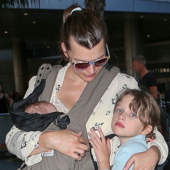 Milla Jovovich, son mari et leurs deux filles Ever et Dashiel arrivent à l'aéroport de LAX à Los Angeles, le 19 juin 2015, où ils viennent de se poser. La famille semble heureuse et passe même du temps avec leurs fans acceptant de poser avec eux pour une photo à l'extérieur du terminal.  Please Hide Children's Face Prior To The Publication - "Resident Evil" star Milla Jovovich, her husband Paul W.S. Anderson and their children Ever and Dashiel arrive on a flight at LAX Airport on June 19, 2015 in Los Angeles, California. The family was all smiles and even posed for pictures with happy fans outside the terminal.19/06/2015 - Los Angeles