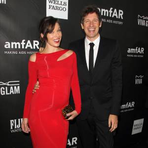 Milla Jovovich (enceinte) (robe Donna Karan) et son mari Paul W.S. Anderson - Soirée amFAR Inspirational gala à Los Angeles le 29 octobre 2014