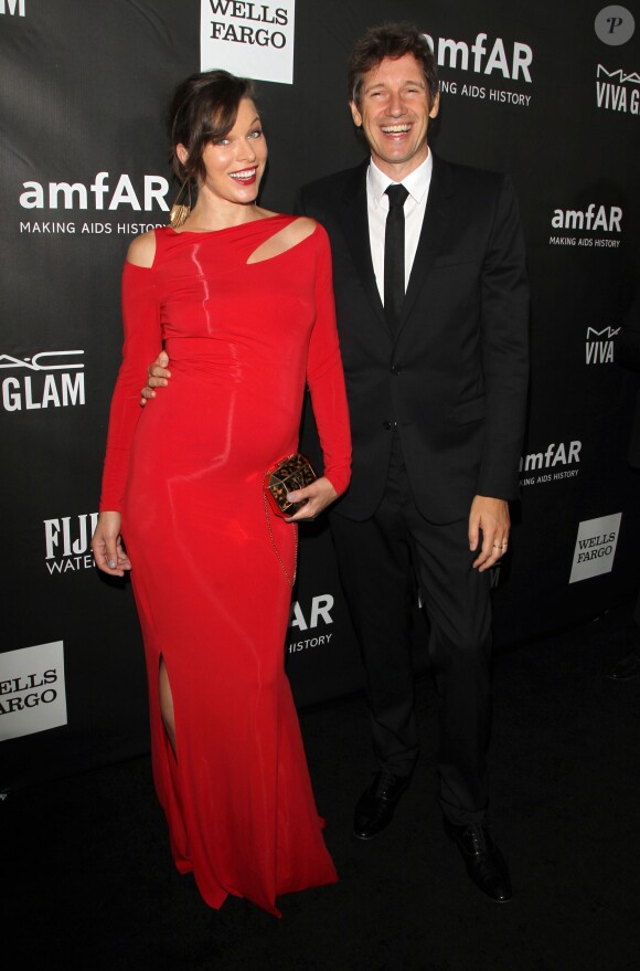 Milla Jovovich (enceinte) (robe Donna Karan) et son mari Paul W.S. Anderson - Soirée amFAR Inspirational gala à Los Angeles le 29 octobre 2014