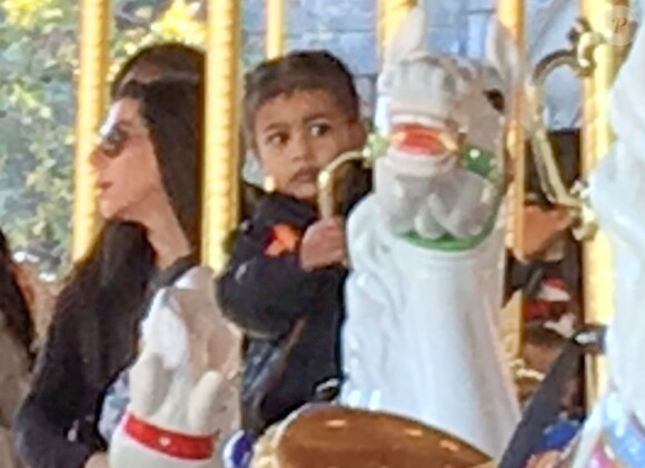 North West (2 ans) fait un tour de manège à Disneyland, où ses cousins Mason et Reign fêtent leurs anniversaires. Anaheim, le 14 décembre 2015.