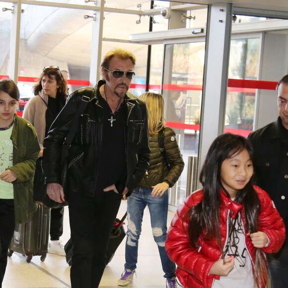 Exclusif - Anne Marcassus et sa fille Giulia, Johnny Hallyday et sa fille Jade - La famille Hallyday arrive à l'aéroport de Roissy pour prendre un vol pour aller passer leurs vacances en Thaïlande avec des amis le 19 décembre 2015