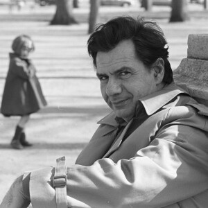Michel Galabru pose en imperméable à Paris le 9 avril 1976