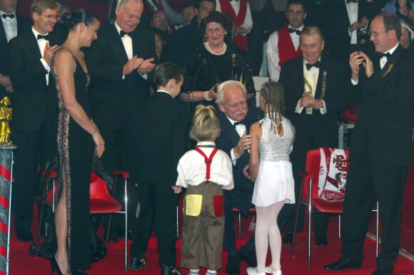 Le prince Rainier III recevant un Clown d'or remis par Louis et Pauline Ducruet et Camille Gottlieb, les enfants de la pricnesse Stéphanie de Monaco, lors du 27e Festival international du cirque de Monte-Carlo en janvier 2003