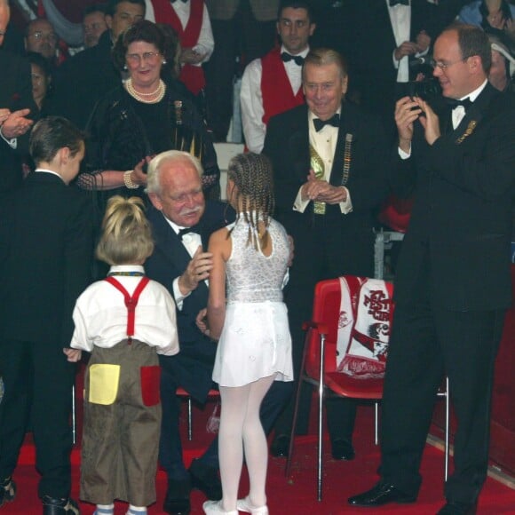 Le prince Rainier III recevant un Clown d'or remis par Louis et Pauline Ducruet et Camille Gottlieb, les enfants de la pricnesse Stéphanie de Monaco, lors du 27e Festival international du cirque de Monte-Carlo en janvier 2003