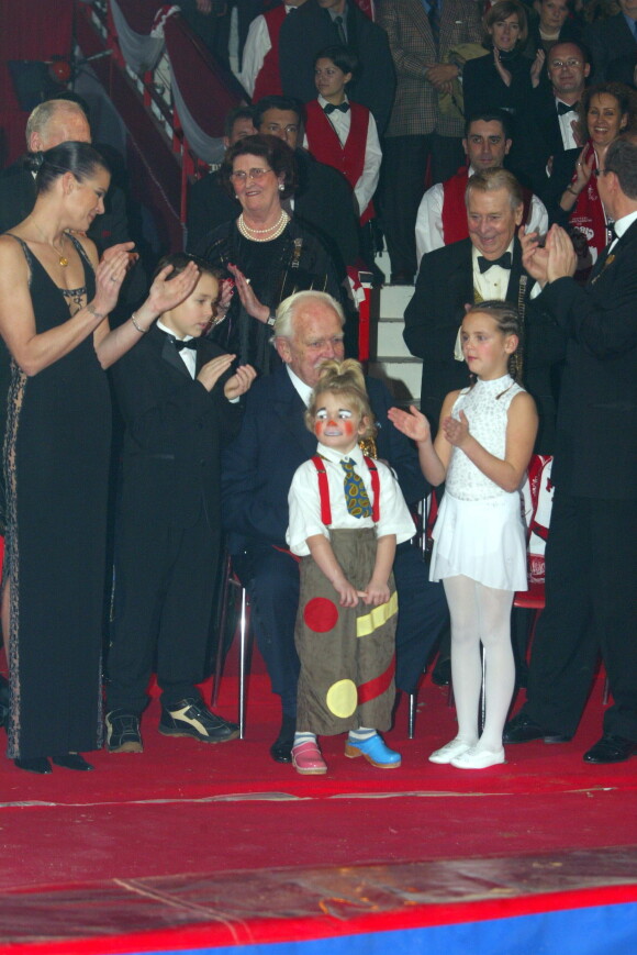 Le prince Rainier III de Monaco recevant un Clown d'or remis par Louis et Pauline Ducruet et Camille Gottlieb, les enfants de la pricnesse Stéphanie de Monaco, lors du 27e Festival international du cirque de Monte-Carlo en janvier 2003