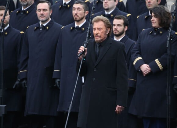 Johnny Hallyday, accompagné par Yodelice et Yarol Poupaud, chante "Un dimanche de janvier" en hommage aux victimes des attentats de janvier et novembre. Place de la République à Paris, le 10 janvier 2016.