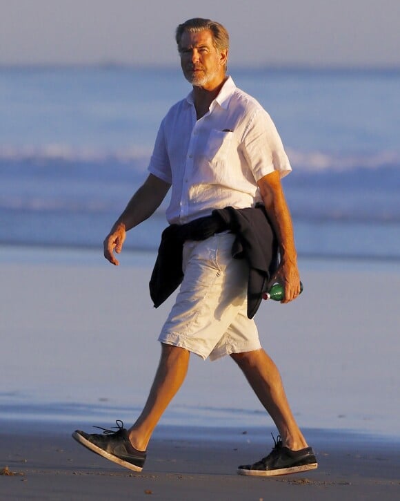 Exclusif - Pierce Brosnan se promène au coucher du soleil sur une plage à Malibu, le 14 novembre 2015