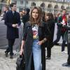 Miroslava Duma arrive au musée du Louvre pour le défilé Christian Dior, habillée d'un trench-coat et d'un sac noir Christian Dior, d'un t-shirt à l'effigie de Micket et d'un jean Vetements. Paris, le 4 mars 2016.