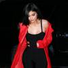 Kylie Jenner vêtue d'une combinaison noire et d'un manteau rouge se promène à New York le 12 février 2016.