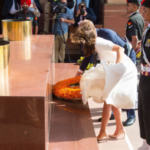 Kate Middleton, obligée de maintenir sa robe Emilia Wickstead, et le prince William déposant une gerbe au pied de la Porte de l'Inde, le monument aux morts à New Delhi, le 11 avril 2016 au deuxième jour de leur tournée officielle en Inde.