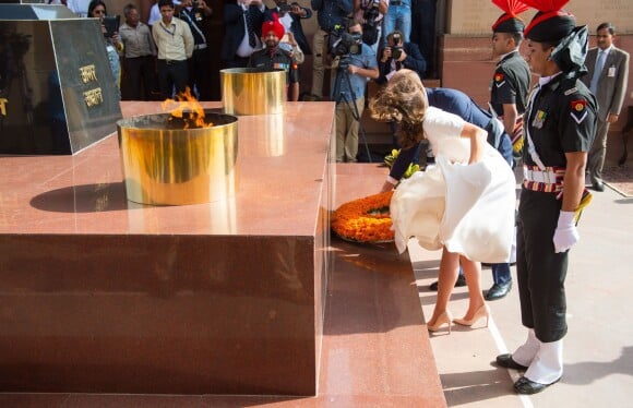 Kate Middleton, obligée de maintenir sa robe Emilia Wickstead, et le prince William déposant une gerbe au pied de la Porte de l'Inde, le monument aux morts à New Delhi, le 11 avril 2016 au deuxième jour de leur tournée officielle en Inde.
