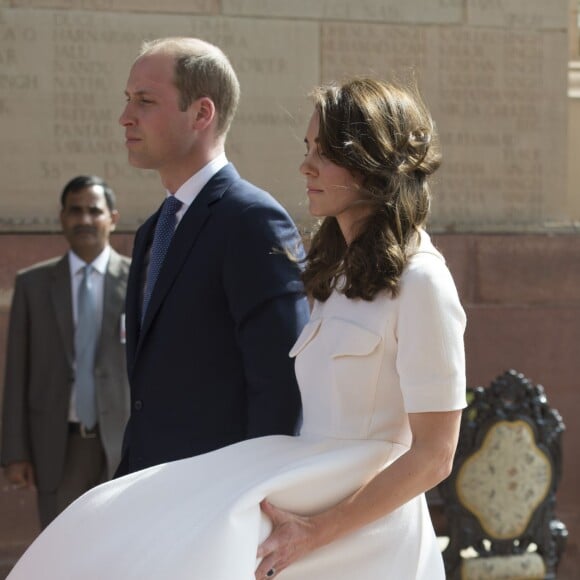 Kate Middleton, qui tient sa robe Emilia Wickstead soufflée par le vent, et le prince William se recueillant au pied de la Porte de l'Inde, le monument aux morts à New Delhi, le 11 avril 2016 au deuxième jour de leur tournée officielle en Inde.