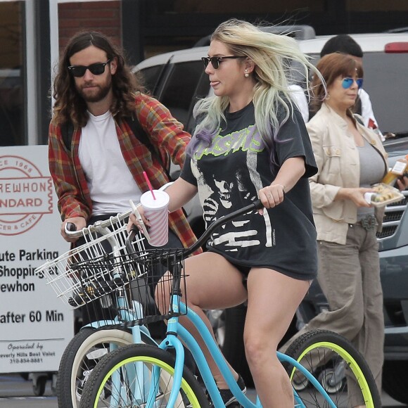 Exclusif - Kesha et son compagnon Brad Ashenfelter se baladent à vélo à Los Angeles, le 7 avril 2016. © CPA/Bestimage