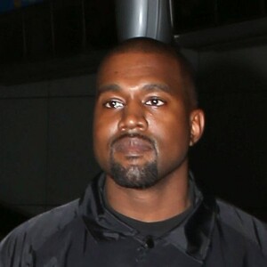 Kim Kardashian portant un décolleté très généreux, et son mari Kanye West arrivent à l'aéroport de Los Angeles (LAX), le 24 mai 2016.