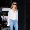 Rosie Huntington-Whiteley de sortie à New York, porte une blouse blanche ARE YOU AM I (modèle Kaede), un jean PAIGE®, un sac "Mini Belt Bag" Céline et des sandales Aquazurra (modèle Tulum 105). Le 8 juin 2016.