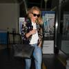 Rosie Huntington-Whiteley à l'aéroport LAX à Los Angeles, porte un bomber en velours Magda Butrym (modèle Tokyo), un t-shirt blanc, un jean PAIGE®, un sac "Mini Belt Bag" Céline et des sandales Gianvito Rossi. Le 8 juin 2016.