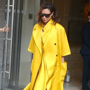 Exclusif - Victoria Beckham quitte un building de New York vêtue d'un ensemble jaune flashy le 23 juin 2016.